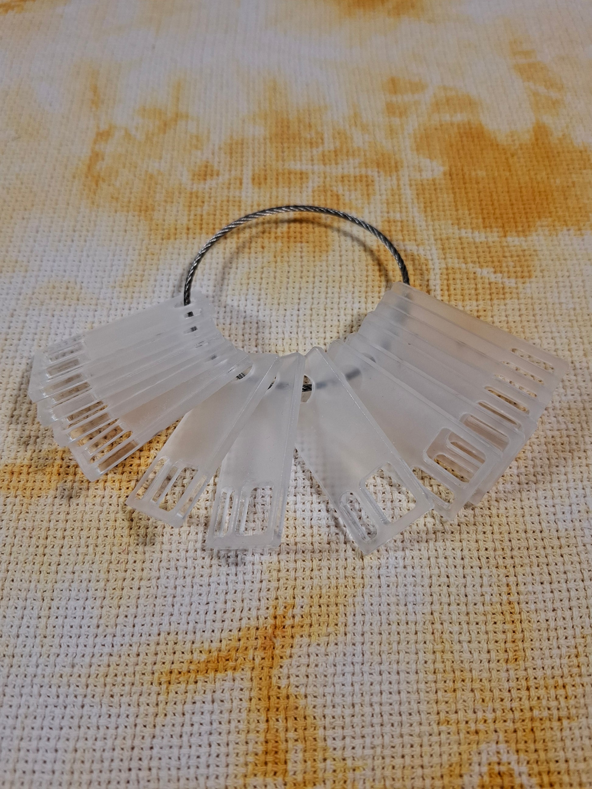 Organizador de hilos de bordar tipo floss drop en acrílico transparente, ideal para proyectos de bordado.