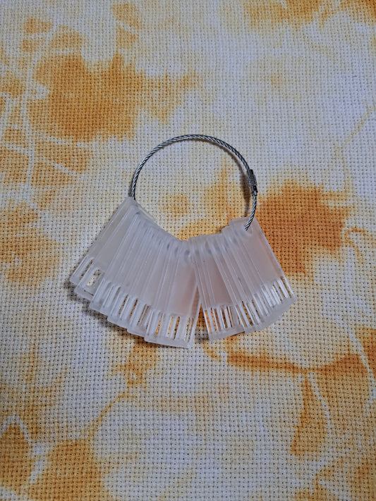 Organizador de hilos de bordar tipo floss drop en acrílico transparente para proyectos de bordado.